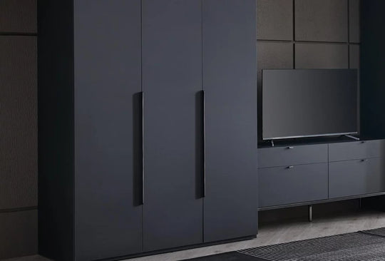 Legato kasten in zwart als wand in een donkere slaapkamer met tv meubel