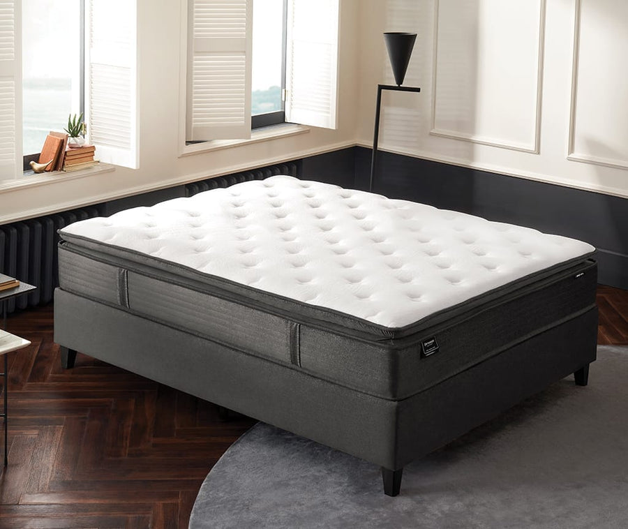 Orthopedic Support matras op een grijs bed bij een raam met gordijnen
