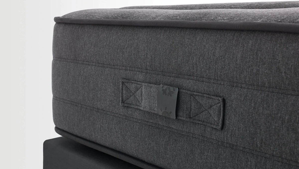 Close-up van de donkergrijze zijkant van het Black Ice matras met label