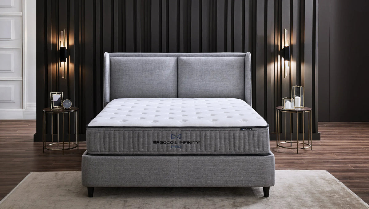 Ergocoil Infinity matras op een grijs bed, vooraanzicht