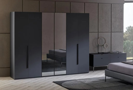 Legato draaideurkast met zes deuren in zwart, met spiegelpanelen in een donkere slaapkamer
