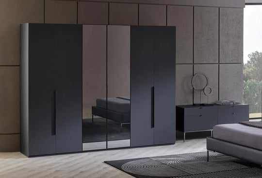 Legato draaideurkast met zes deuren in zwart, met spiegelpanelen in een donkere slaapkamer