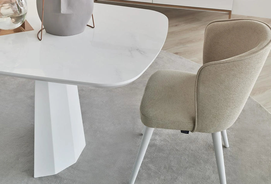 Legato stoel aan een witte eettafel met een marmerlook blad