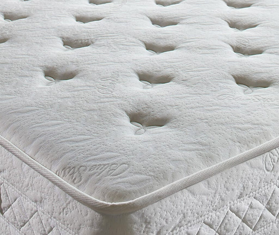 Close up van de gecapitonneerde witte bovenkant en de gestikte rand van het Blue Star matras