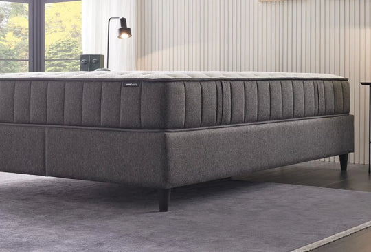 Ionic Energy matras met grijze verticaal gestikte zijkant op een donkergrijze boxspring