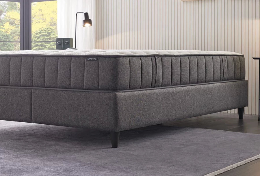 Ionic Energy matras met grijze verticaal gestikte zijkant op een donkergrijze boxspring