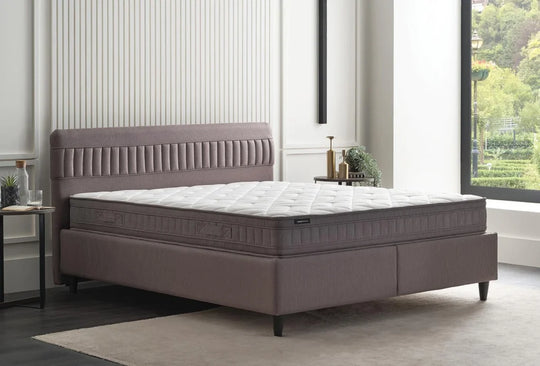 Sleep Balance baza met ribbelhoofdbord en matras in een lichte slaapkamer