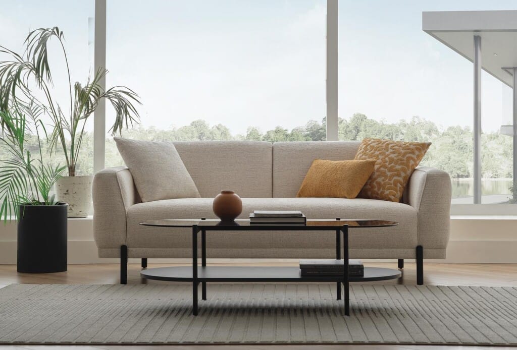 Terra 2,5 zitsbank in creme in een lichte woonkamer met planten en salontafel