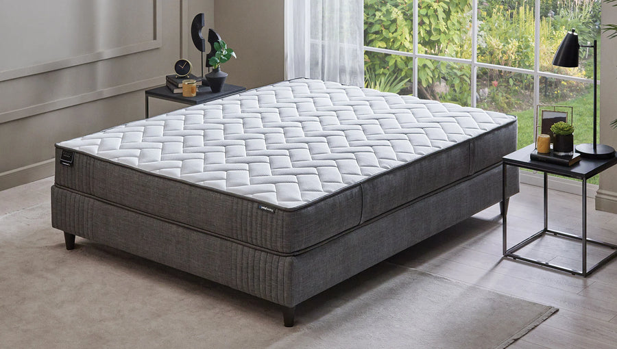 Wool Sense Pro matras op een grijze boxspring in een slaapkamer met groot raam