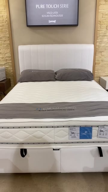 Wit bed met matras in de showroom